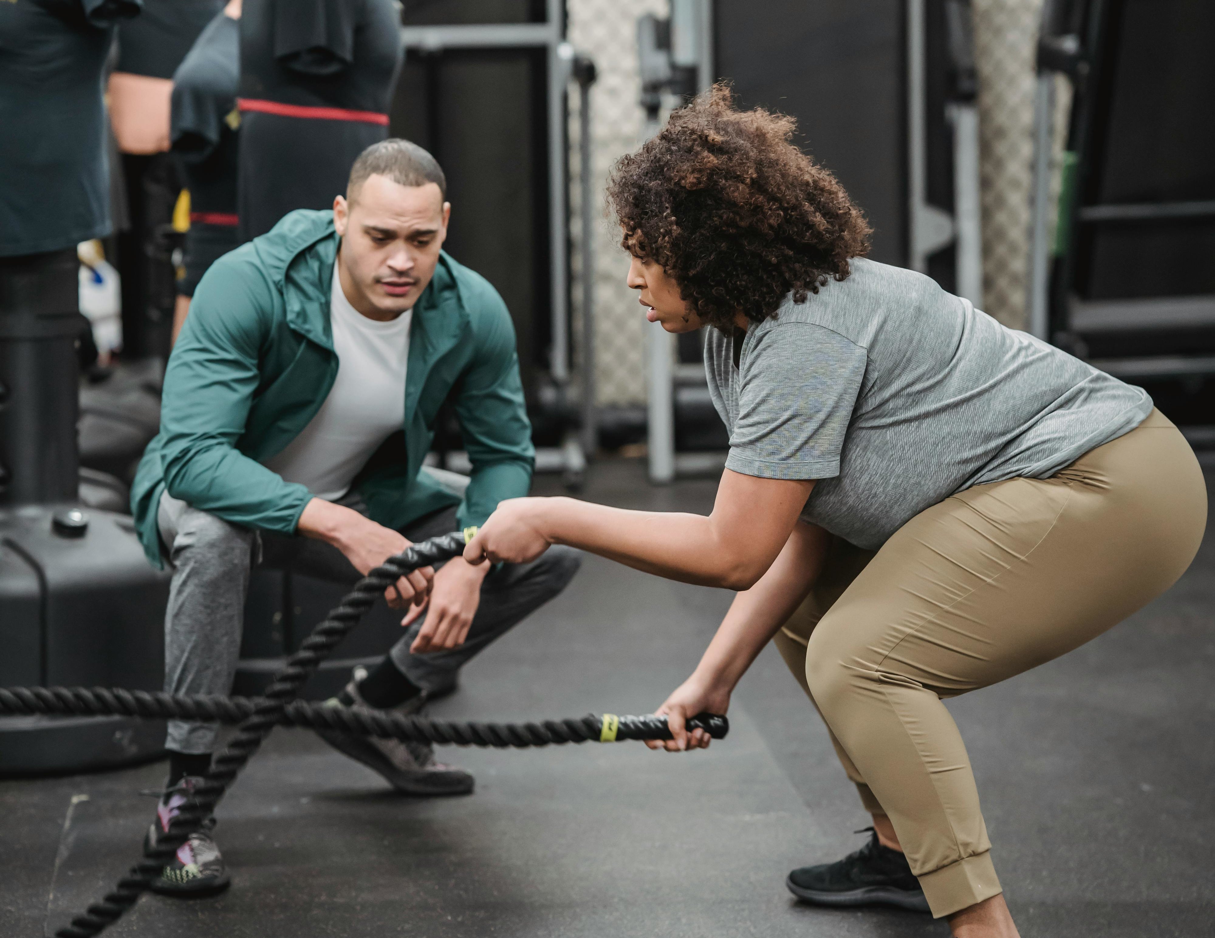 Independent personal trainer working with a client in a gym